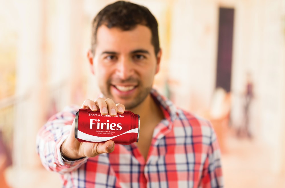 Man holding a Share a Coke with the Firies can