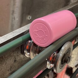 Pink wine closure on manufacturing line
