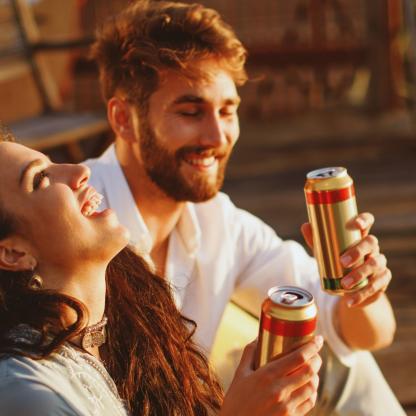 Two people drinking from cans